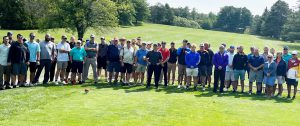 large group of golfers pose on the green