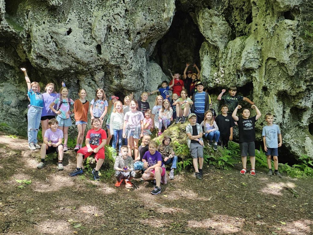 group of elementary students pose in a cave