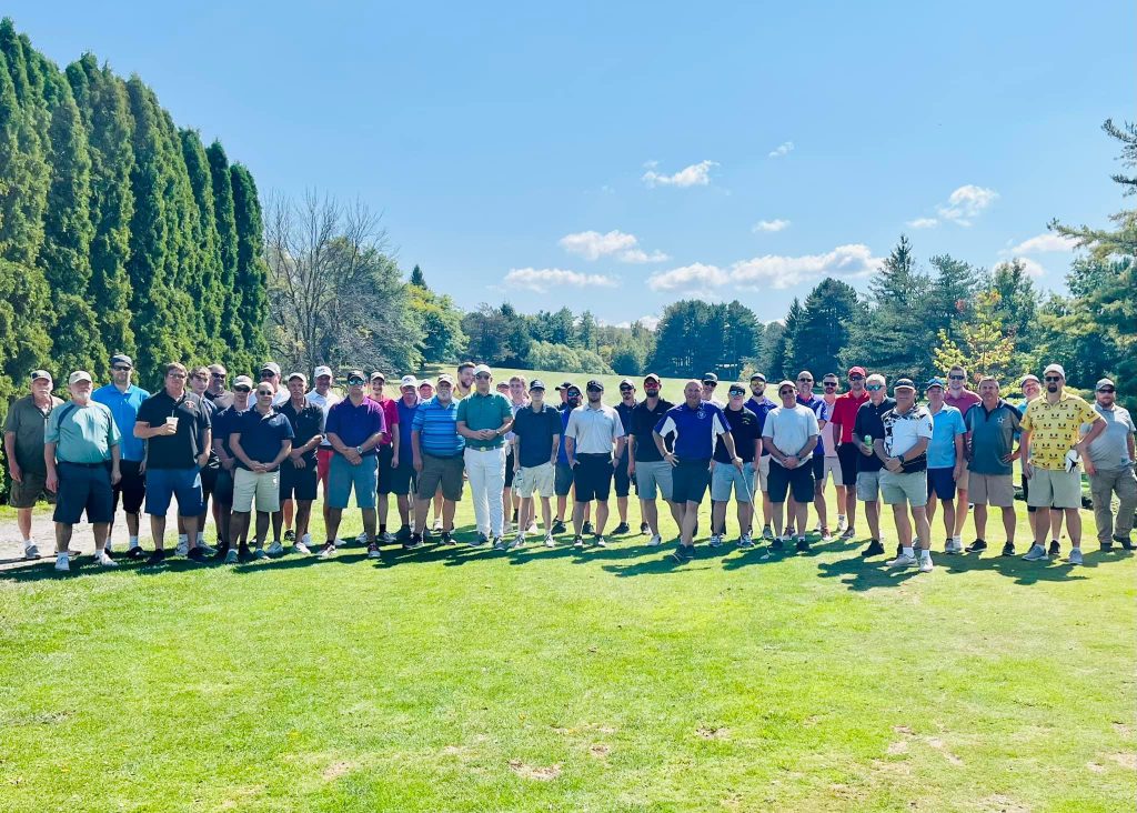 large group of golfers gather at the first tee