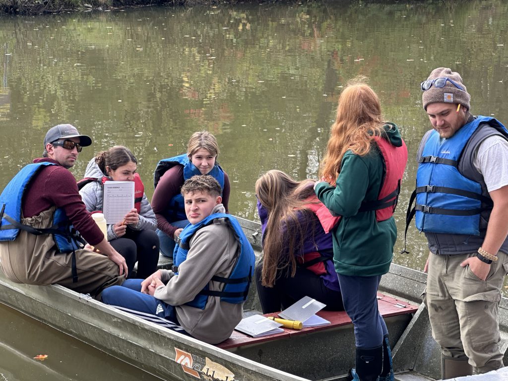 students in a fishing bond on a pond