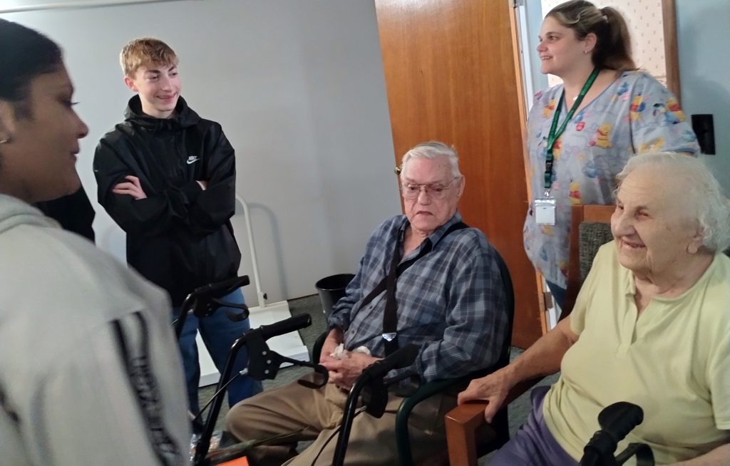 high school students visit with senior citizens