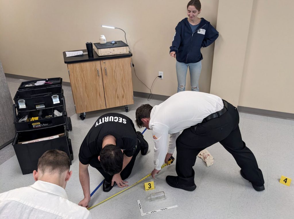 students works with other students on a CSI investigation