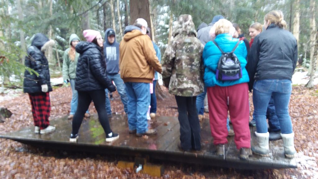 group of students on the challenge course at camp