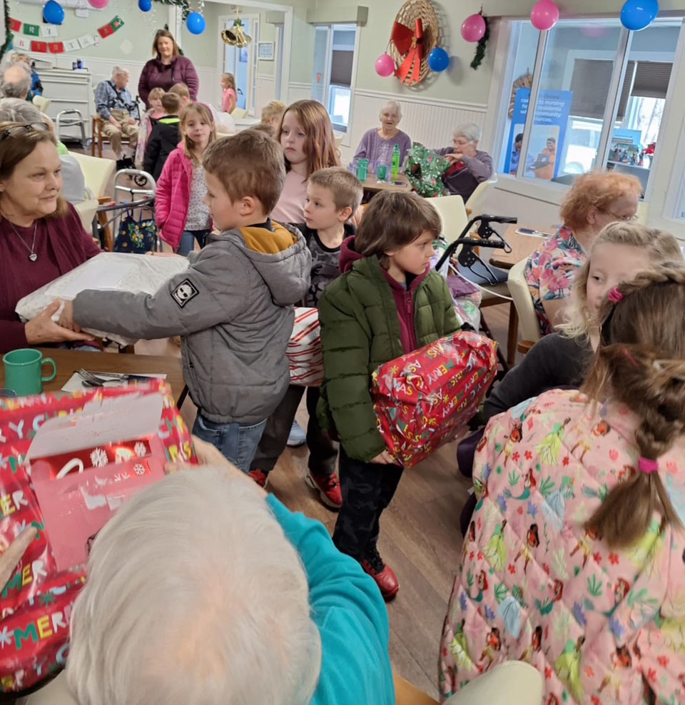 kids pass out gifts at senior center