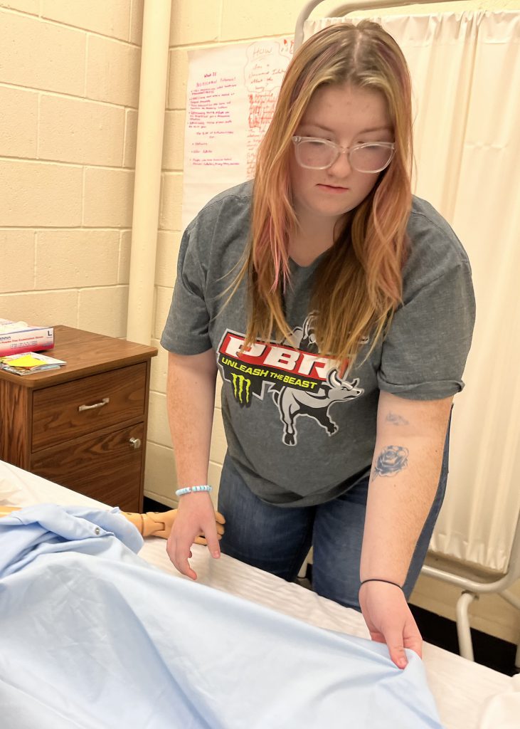 student nurse makes a bed