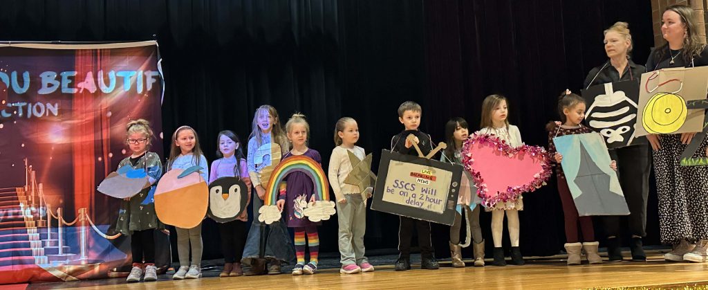 Kindergarteners dress as alphabet items on stage